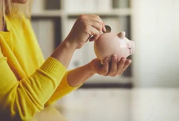 Lady putting money in piggy bank